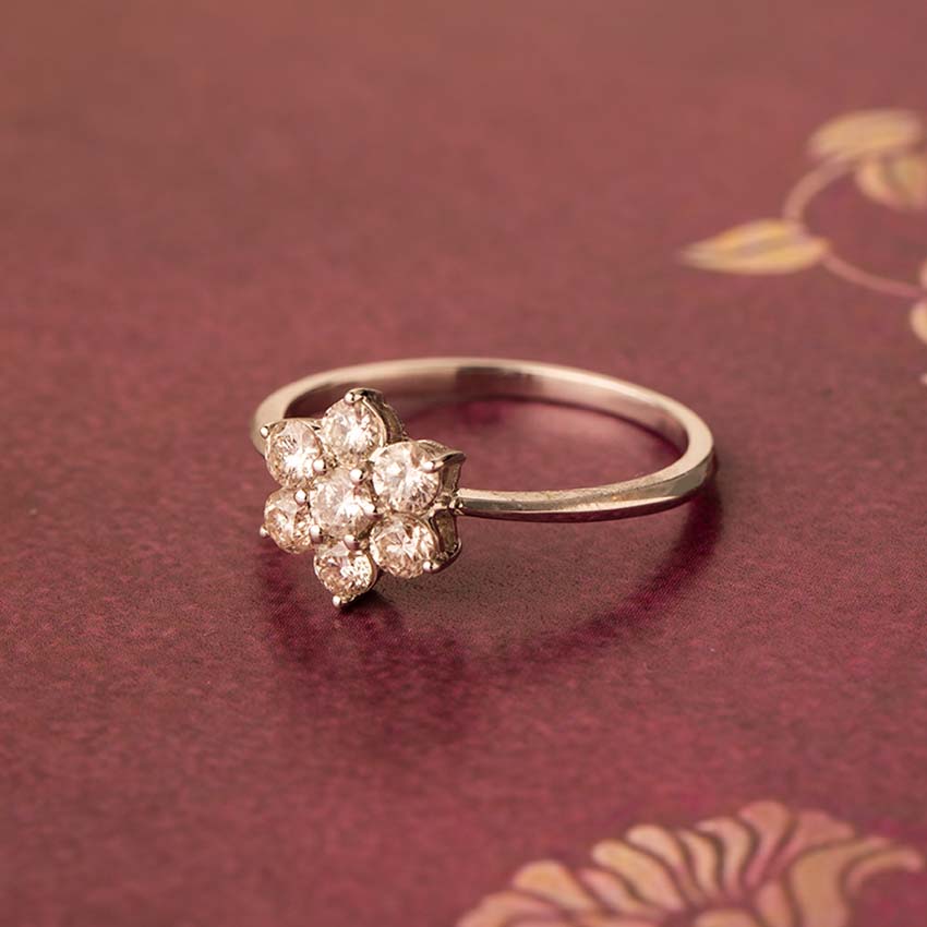 Gold ring with diamond flowers on a red background
