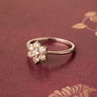 Gold ring with diamond flowers on a red background