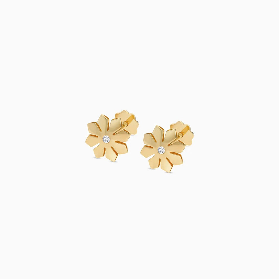 A pair of gold flower stud earrings with a small clear crystal in the center of each flower, shown on a plain white background.