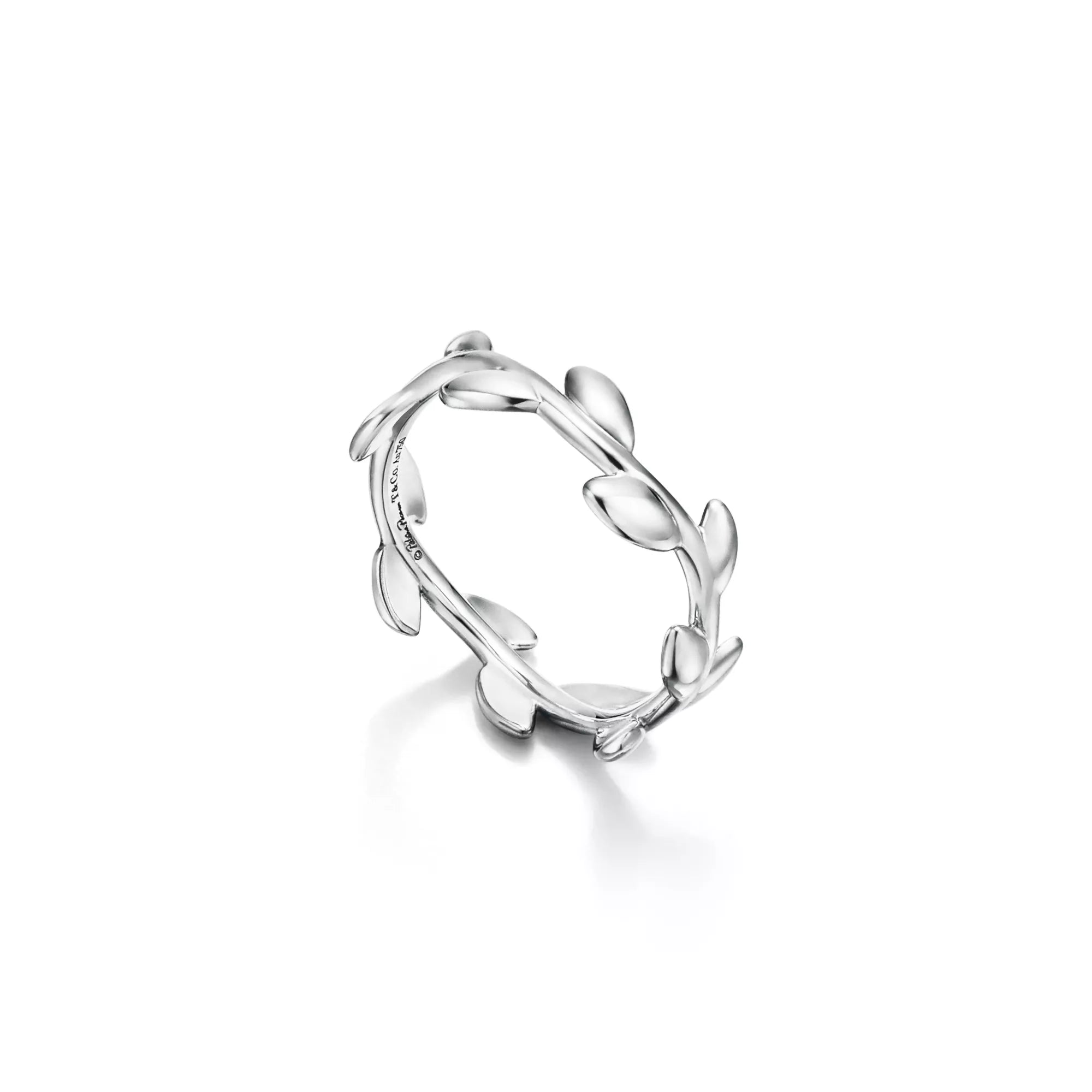 A silver ring designed with a continuous leafy vine pattern, shown on a clean white background with a soft reflection underneath.