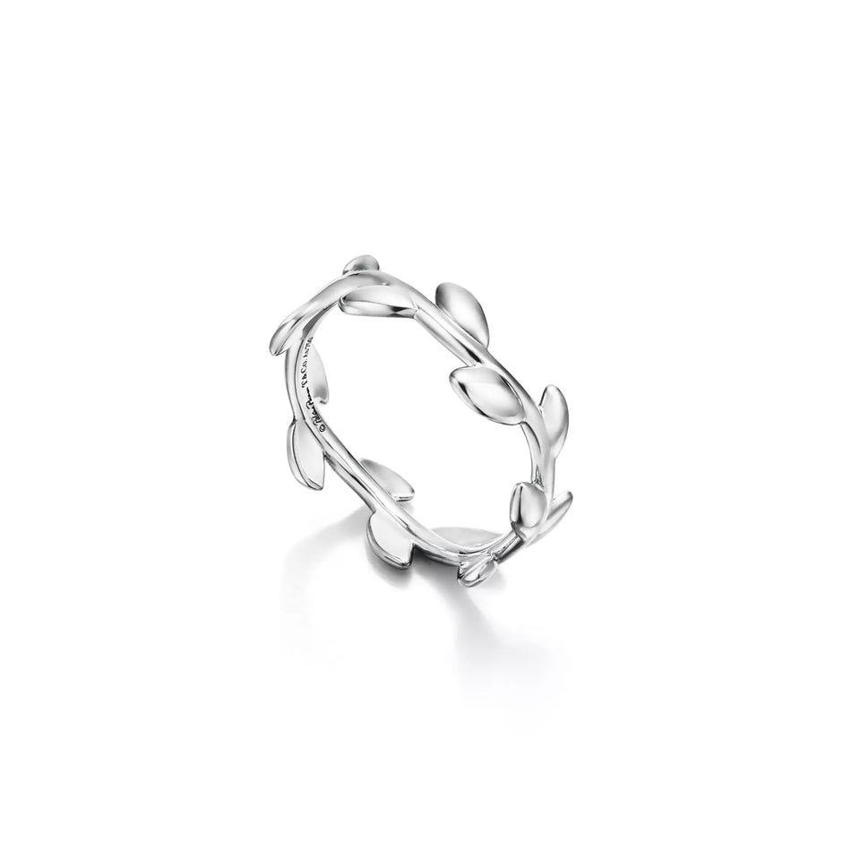 A silver ring designed with a continuous leafy vine pattern, shown on a clean white background with a soft reflection underneath.
