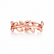 A polished rose Silver ring designed as a leafy vine branch, shown on a clean white background with a soft reflection.