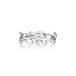 A silver ring designed as a leafy branch wreath, shown on a clean white background with a soft reflection underneath.