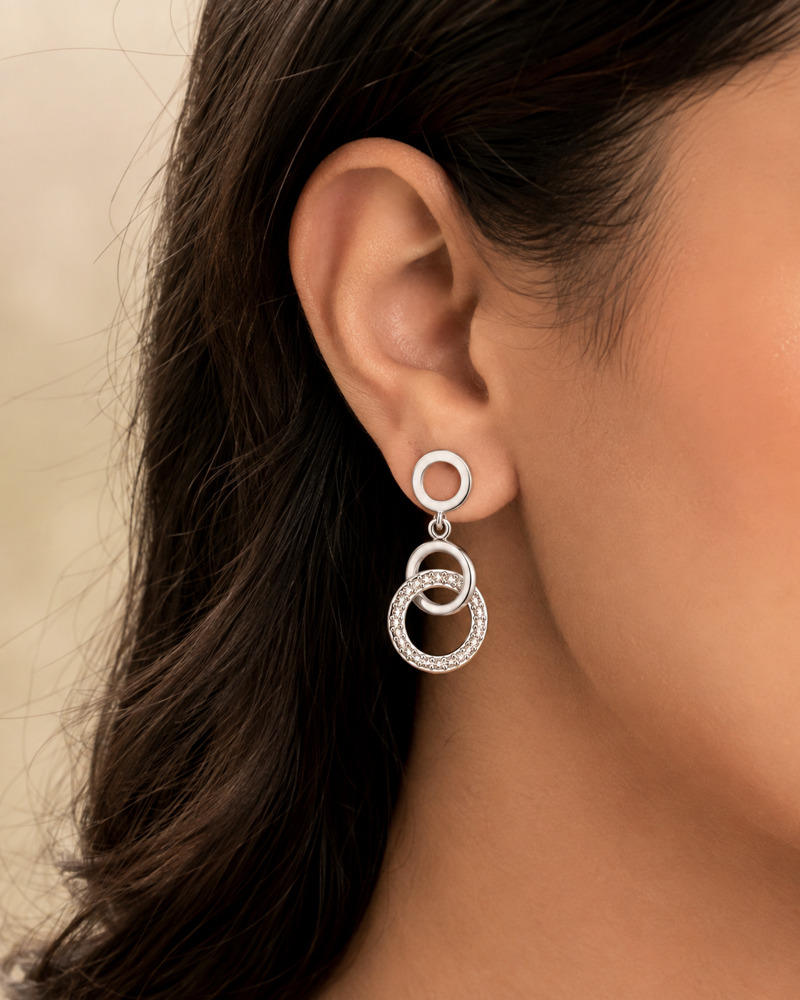 Abeer Twisted Circle Silver Drop Earrings worn on a woman's ear, white 925 sterling silver lifestyle view