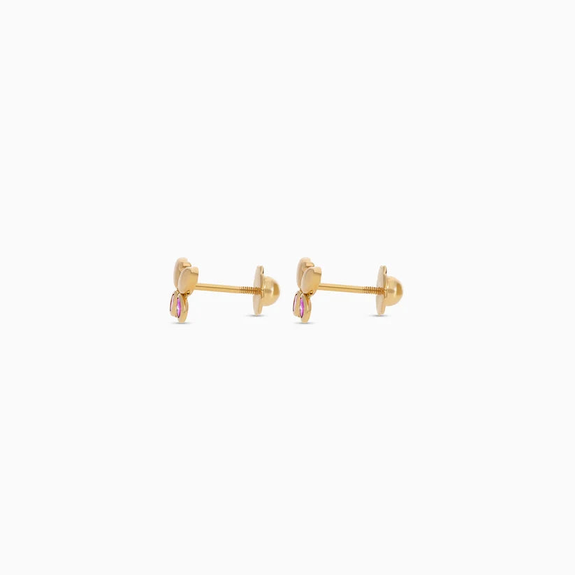 A pair of gold post earrings with a small heart-shaped charm and a dangling pink oval stone, shown against a plain white background.