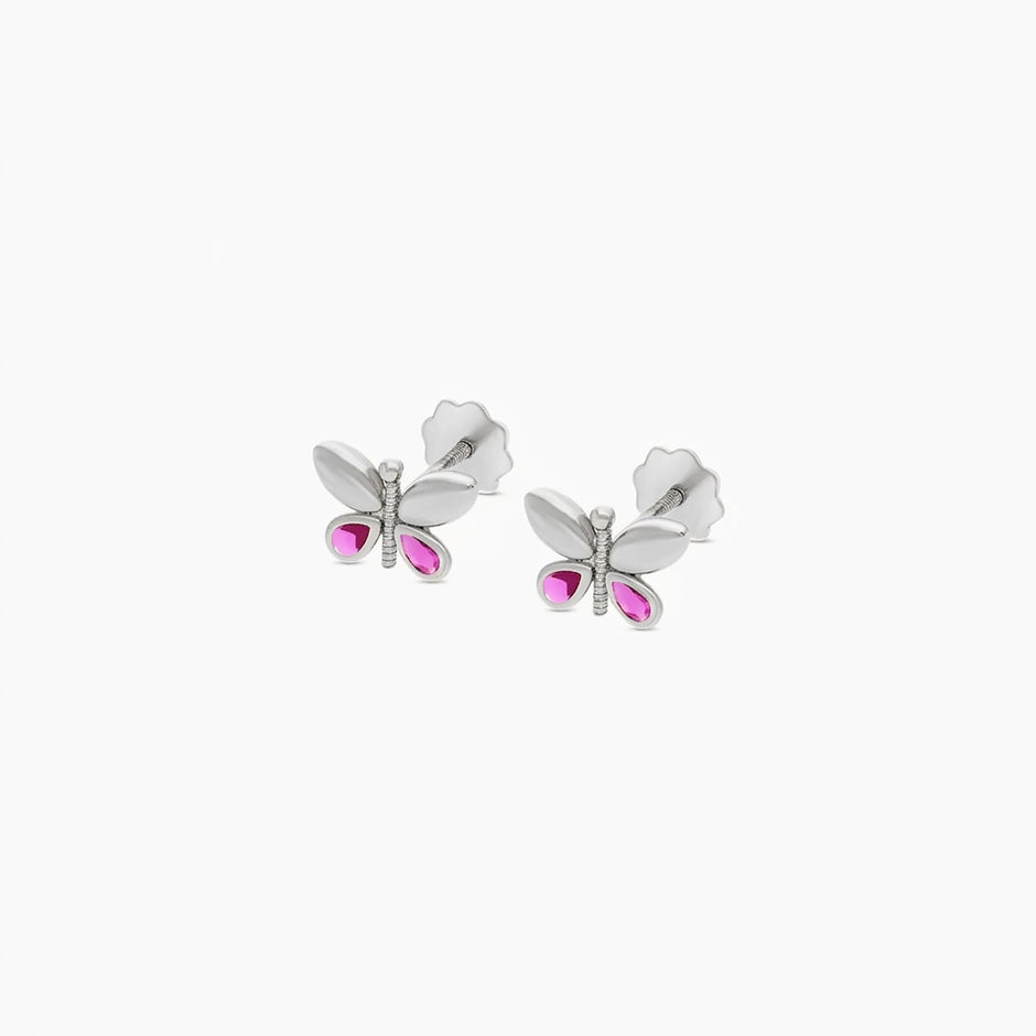 A pair of white butterfly stud earrings with bright pink gemstone accents, shown on a clean white background.