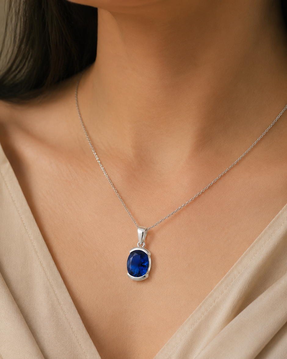 Saba Sapphire Half-Bezel Silver Pendant worn at a woman's neckline on a fine chain, white 925 sterling silver lifestyle view